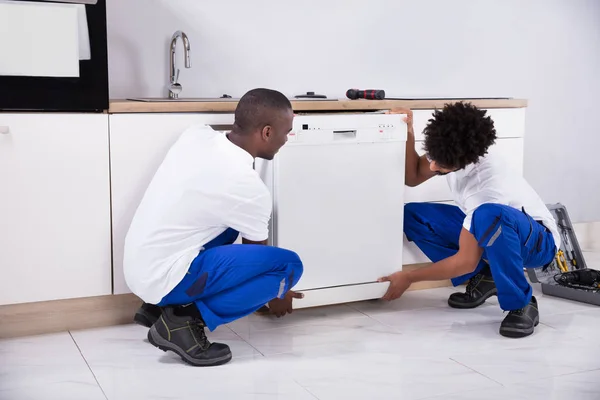 Close Two Young Handy Men Uniform Fixing Dishwasher Kitchen — Stock Photo, Image