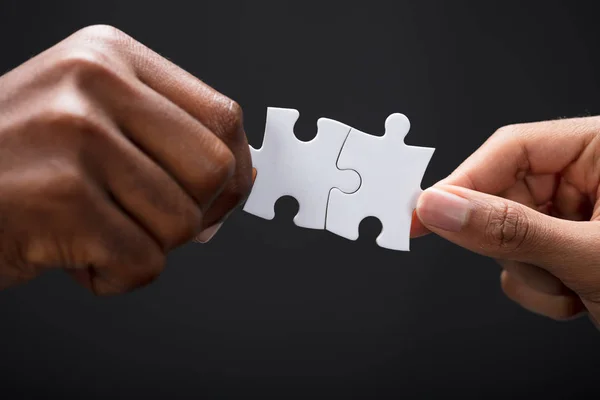 Close Üzleti Partnerek Egyesítése Két Fehér Puzzle Darab Fekete Háttér — Stock Fotó