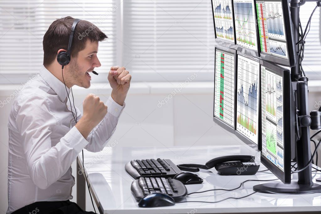 Side View Of A Happy Male Stock Market Broker Looking At Rising Stock Charts