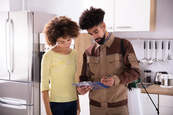 Trabajador Control Plagas Masculino Joven Que Muestra Factura Mujer Cocina — Foto de Stock