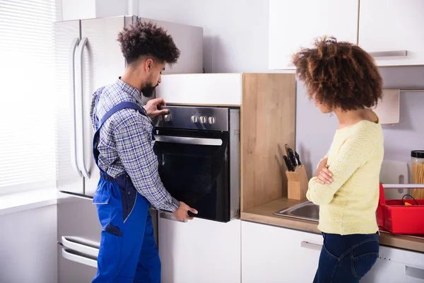 Mujer Mirando Joven Reparador Fijar Horno Cocina — Foto de Stock