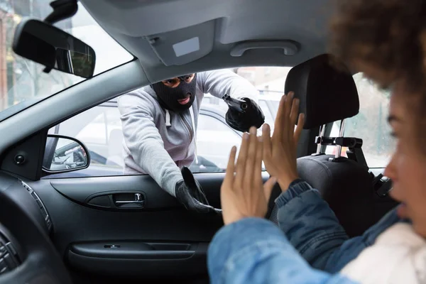Злодій Балаклаві Загрожує Жінці Зброєю Під Час Крадіжки Рюкзака Автомобіля — стокове фото