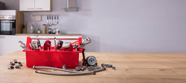 Toolbox With Different Worktools On Wooden Desk