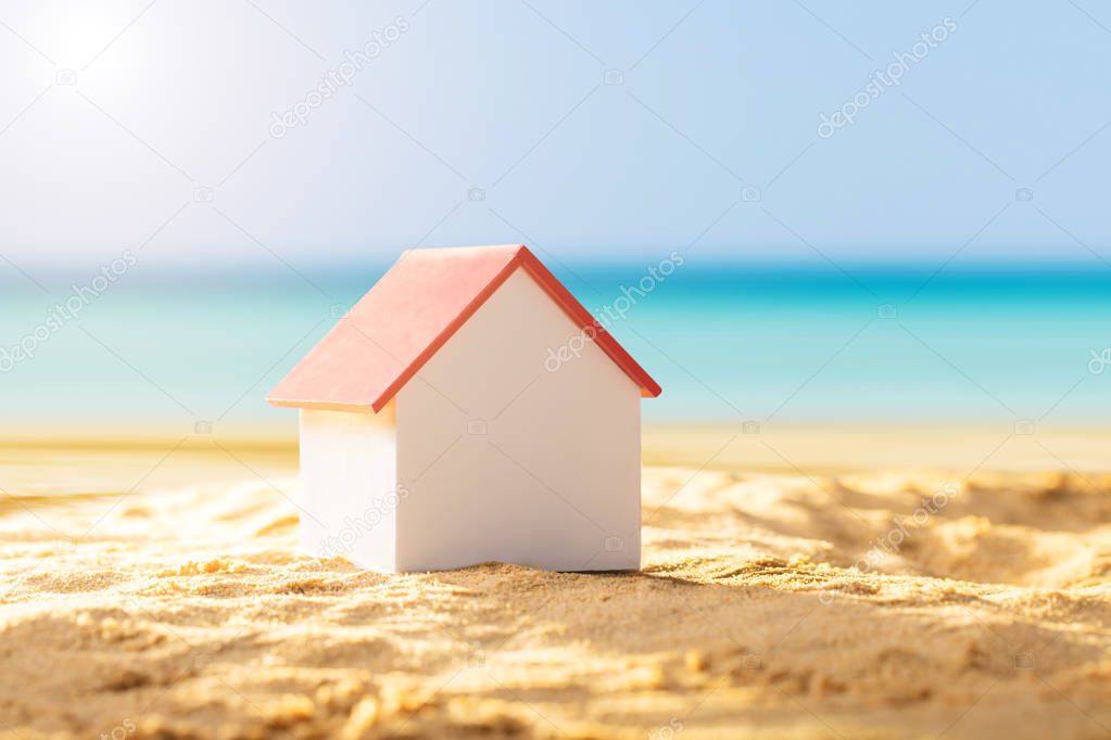 Close-up Of A House Model With Red Roof On Sandy Beach