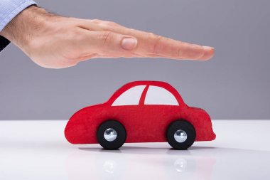 İnsan eli kırmızı araba gri arka plan karşı koruma