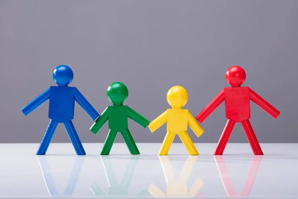 Multi Colored Human Figures Standing Together Row White Desk — Stock Photo, Image