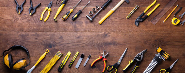 Overhead View Of Many Yellow Repair Tools Arranged On Wooden Table