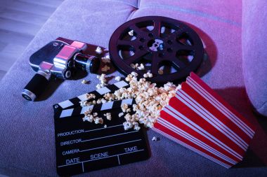 High Angle View Of Spilled Popcorn With Clapperboard And Movie Camera At Night clipart
