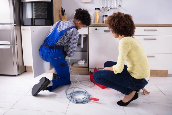 Woman Looking Male Plumber Cleaning Clogged Pipes — Stock Photo, Image