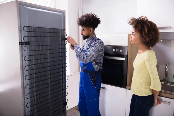 Mulher Que Olha Para Técnico Que Repara Refrigerador Com Chave — Fotografia de Stock