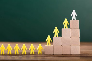 Beyaz rakam ahşap bloklar üzerine sarı insan figürleri sınıfta lider Close-Up