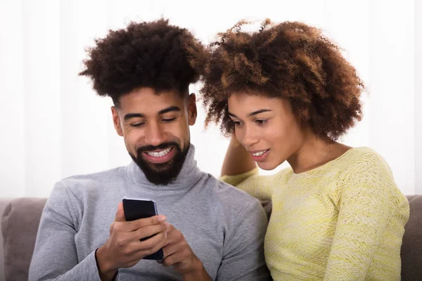 携帯電話を見て若いの幸せなカップルのクローズ アップ — ストック写真