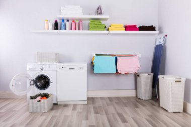 Sepet dolusu kirli çamaşırları çamaşır makinesi, çamaşır odası önünde