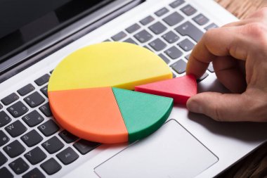 Son parçayı pasta grafikte Laptop tuş üzerinde yerleştirerek bir insan eli Close-Up