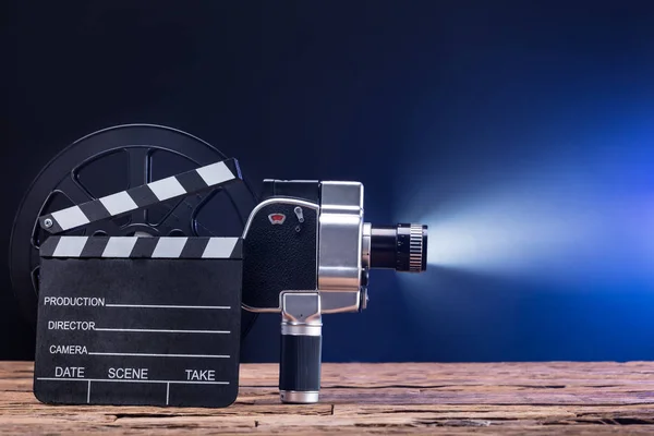 Close Illuminated Movie Camera Film Reel Clapper Board Wooden Desk — Stock Photo, Image