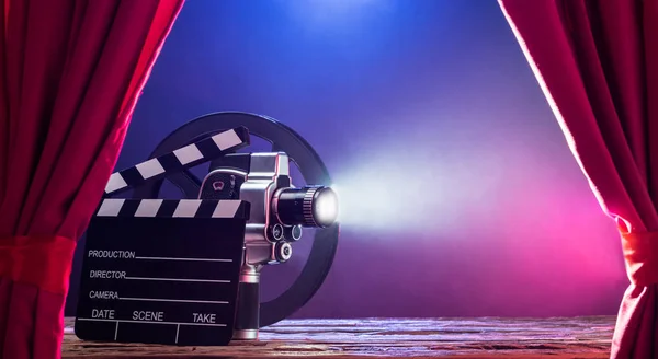 Clapperboard 和胶片卷轴的照明电影相机对彩色背景 — 图库照片