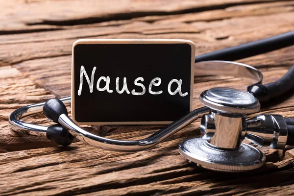Close Stethoscope Slate Showing Nausea Text Wooden Background — Stok Foto