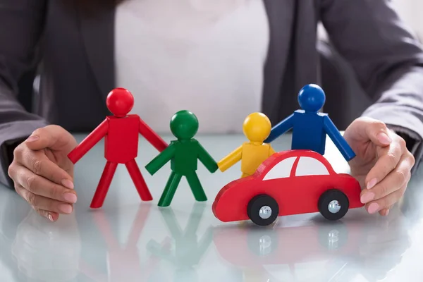 Close Businessperson Hand Protecting Multi Colored Human Figures Red Car — Stok Foto