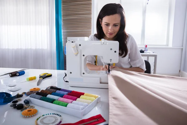 女时装设计师在画室缝纫机上缝制面料 — 图库照片