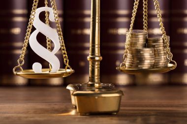 Beyaz paragraf sembolü ve adalet ölçekte yığılmış altın sikke yakın çekim