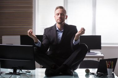 Ofiste Resepsiyon meditasyon üzerinde oturan genç işadamı