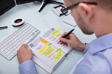 İşadamı el yazma programı işyerinde kalemiyle Diary