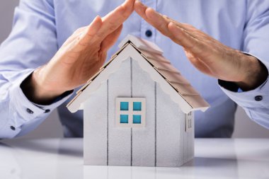 Bir insan eli ev Model beyaz masa üzerinde koruma Close-Up