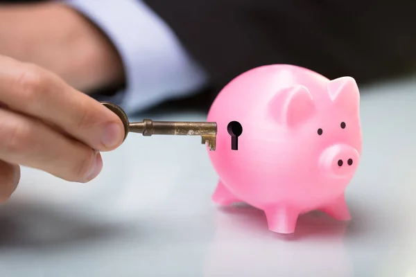 Close Person Hand Inserting Key Piggy Bank Keyhole — Stock Photo, Image