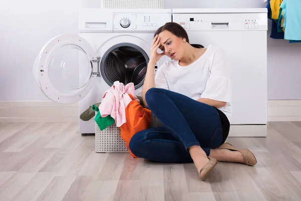 Mujer Joven Agotada Sentada Frente Lavadora Con Cesta Llena Ropa — Foto de Stock