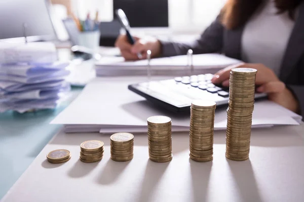 Primer Plano Del Aumento Monedas Apiladas Frente Mujer Negocios Calculando —  Fotos de Stock