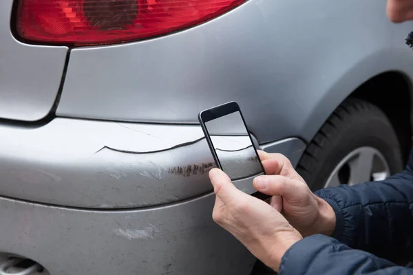 Närbild Persons Hand Foto Skadad Bil Genom Smartphone — Stockfoto