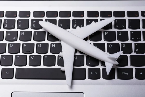 Erhöhte Ansicht Der Weißen Flugzeug Miniatur Auf Der Laptop Tastatur — Stockfoto