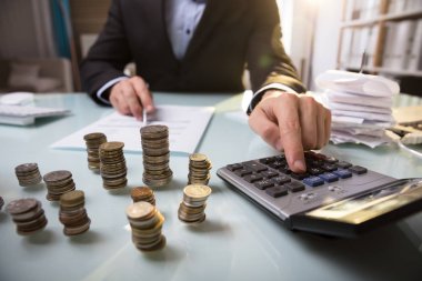 Belge üzerinde çalışmayı işadamı önünde yığılı sikke yakın çekim