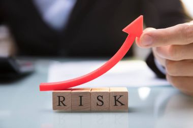 Kırmızı ok Risk blokları üzerinde tutan bir işadamının'ın el Close-Up