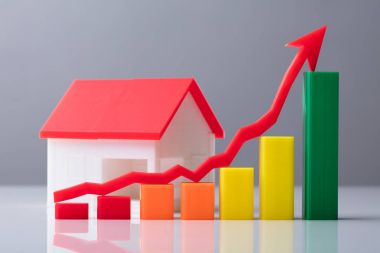 İş grafiği ve ev modeli önündeki kırmızı ok işareti Close-Up