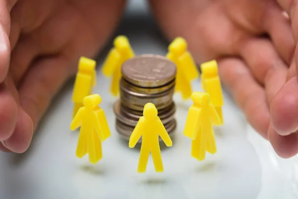 Close Businessperson Hand Protecting Stacked Coins Surrounded Yellow Human Figures — Stock Photo, Image