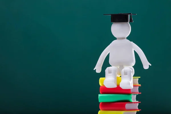 Figura Humana Con Sombrero Graduación Sentado Libros Apilados Multicolores — Foto de Stock