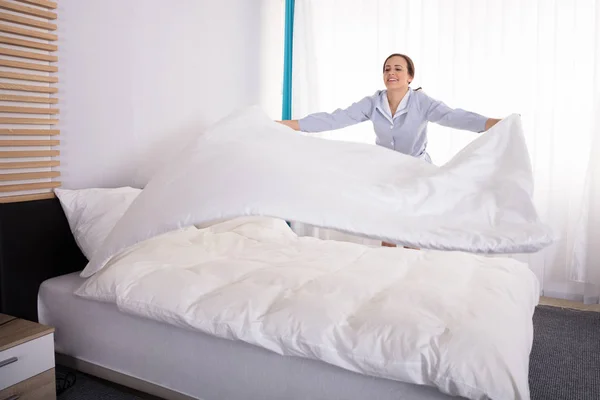Smiling Young Female Housekeeper Housekeeper Arranging Bedsheet Bed Hotel Room — Stock Photo, Image