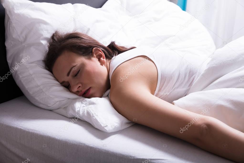 Close-up Of A Young Woman Sleeping On Bed