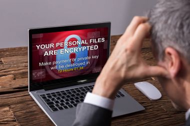 Close-up Of A Businessperson Looking At Laptop Screen Showing Personal Files Encrypted Text clipart