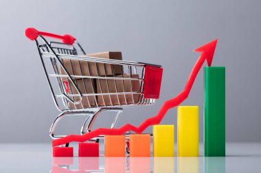 Alışveriş sepeti önünde yukarı doğru yönü gösteren ok işareti ile grafik kutuları dolu