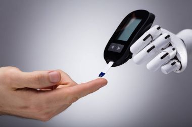 Kişinin şeker düzeyi ile Şeker Ölçüm gri arka plan kontrol Robot bir el Close-Up