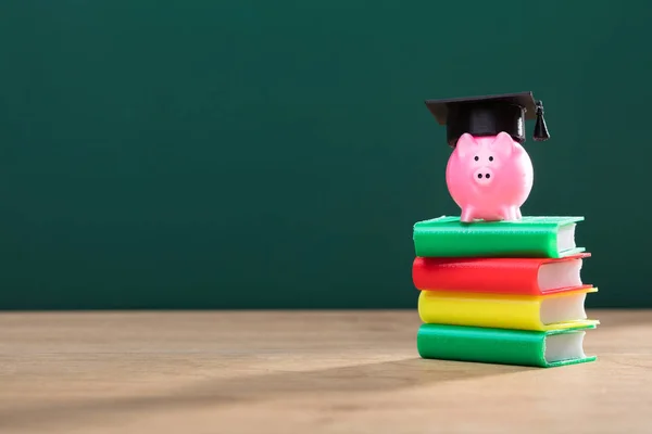 Primo Piano Del Salvadanaio Con Cappello Laurea Più Libri Accatastati — Foto Stock