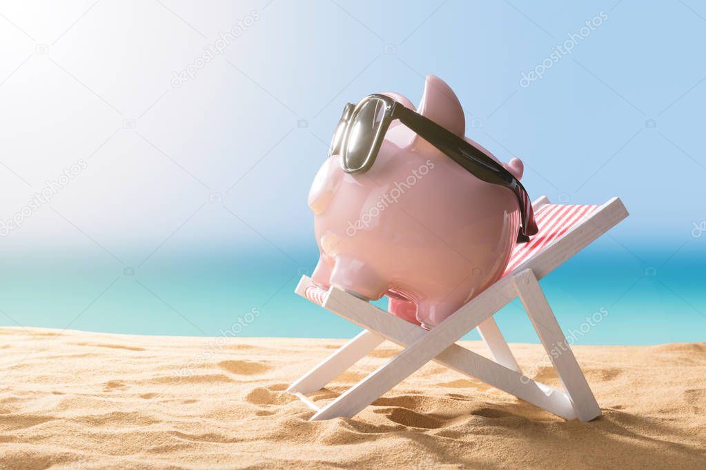 Close-up Of A Pink Piggy Bank Wearing Sunglasses Relaxing On Deck Chair