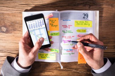 Bir işadamının cep telefonu yazma programı Diary ile yüksek açılı görünüş