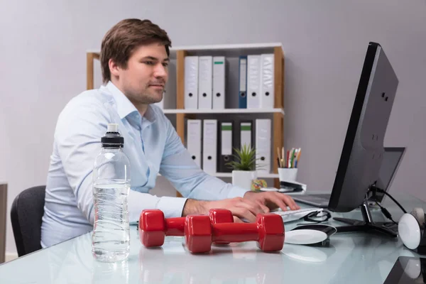 Pengusaha Bekerja Komputer Dengan Botol Air Dan Dumbbell Pada Meja — Stok Foto