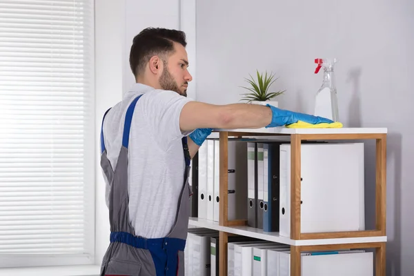 職場の棚を洗浄クリーナー若い男性のクローズ アップ — ストック写真