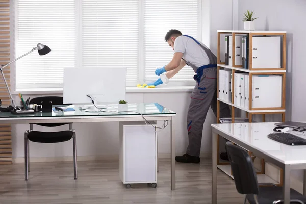 Jeune Homme Concierge Nettoyage Fenêtre Sill Avec Éponge Dans Bureau — Photo