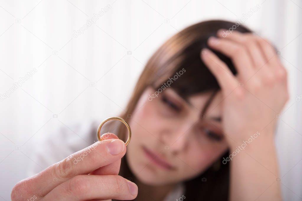 Upset Woman's Hand Holding Wedding Gold Ring