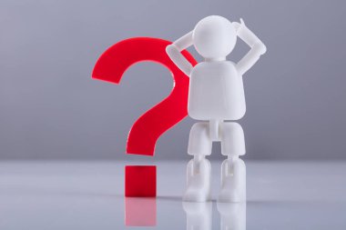 İnsan figürü gri arka plan üzerinde kırmızı soru işareti işaret yanında ayakta